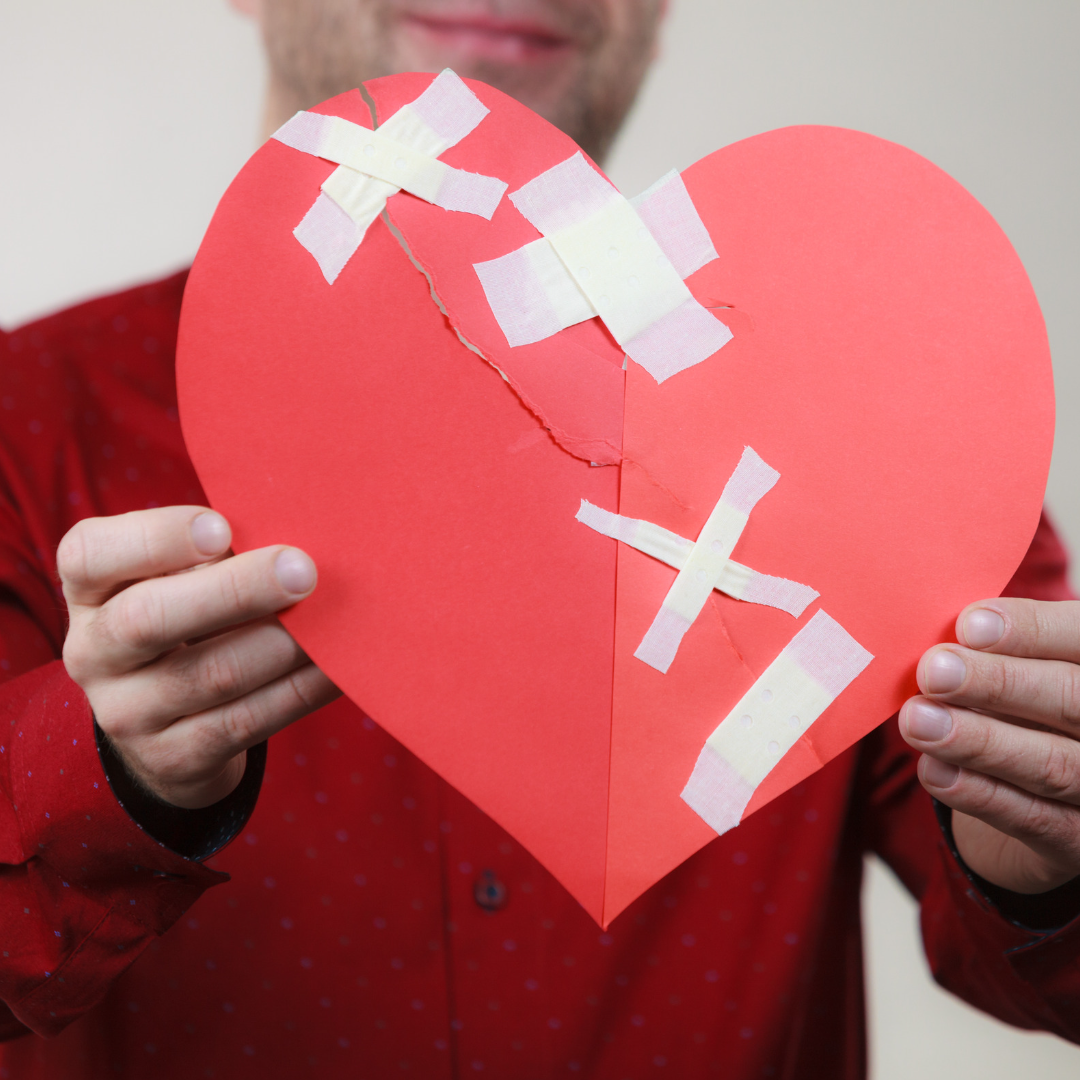 A taped up paper heart symbolizing managing your feelings about Valentine's Day after divorce.